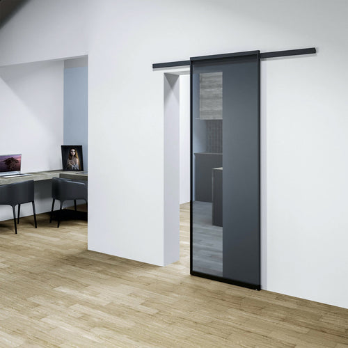 Modern sliding door in a minimalistic interior setting with wooden flooring and white walls.