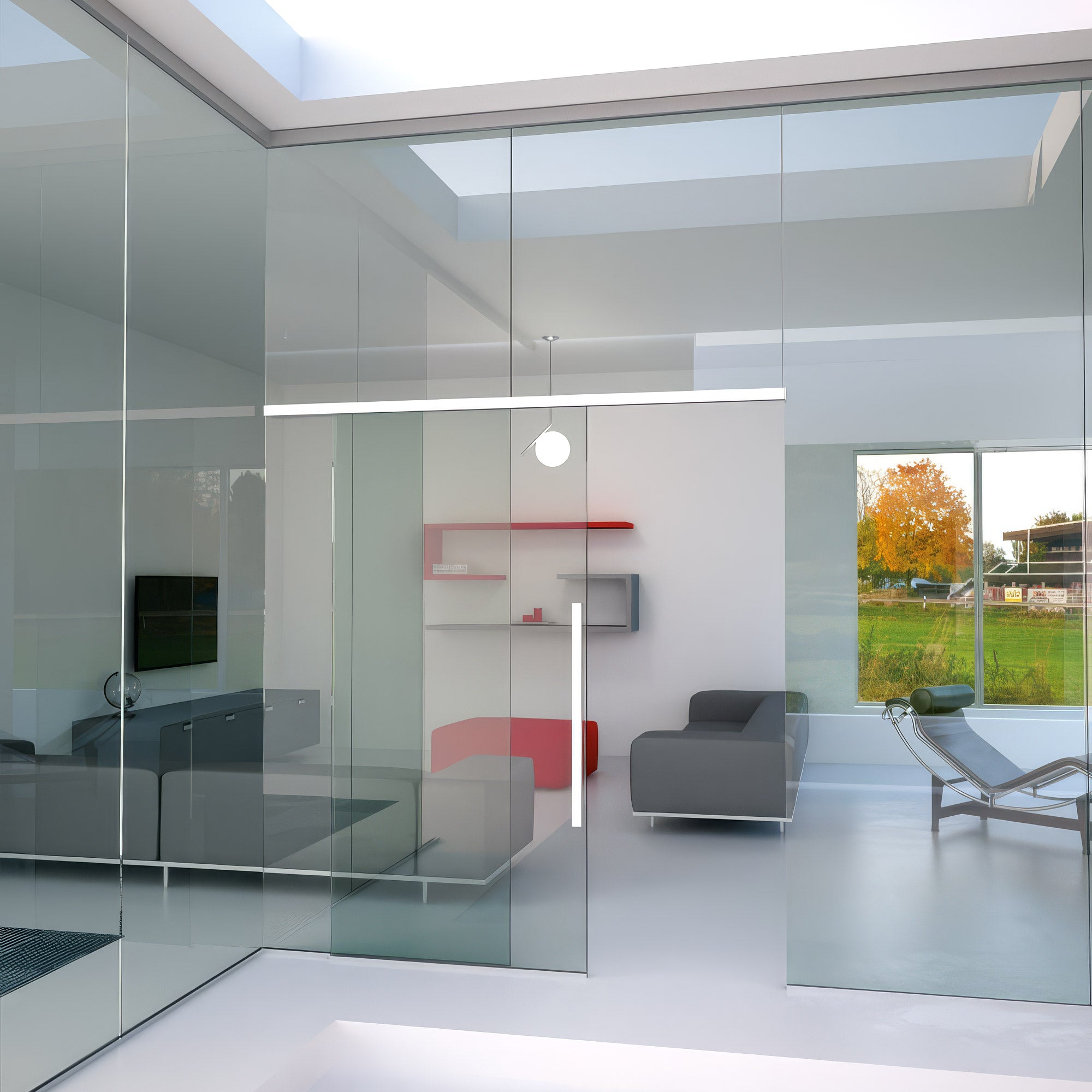 Modern interior design with glass walls, gray furniture, and a view of trees outside.