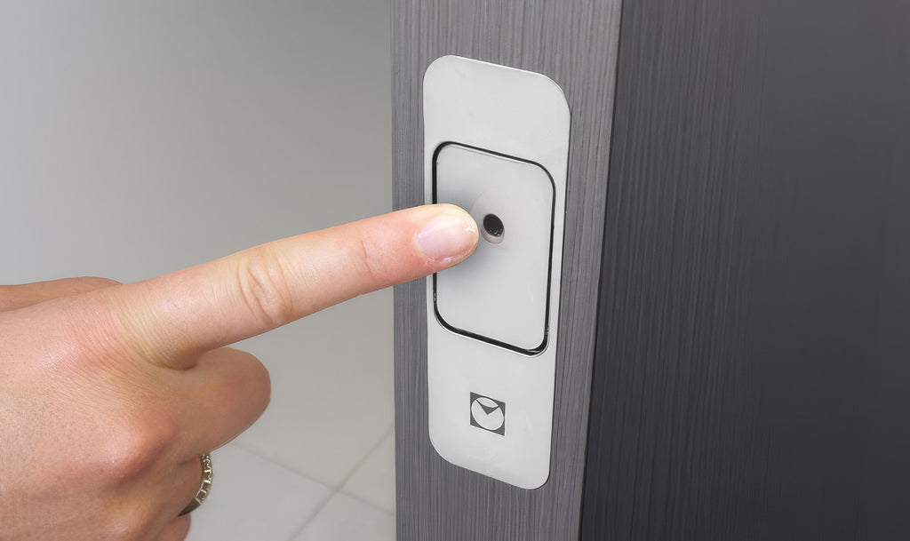 Close-up of Push&Go EVO installed on a door, with a hand demonstrating how it opens.